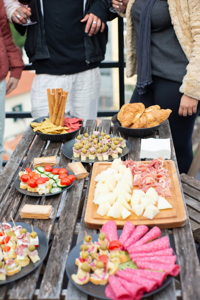 footer-cta Lively outdoor gathering with a variety of Portuguese tapas on a rustic wooden table.